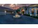 Home entrance with fountain and paved driveway at dusk at 3218 Signet Ct, Sarasota, FL 34240