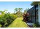Expansive backyard featuring lush green grass and meticulous landscaping including tropical foliage at 15923 29Th E St, Parrish, FL 34219