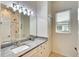 Well-lit bathroom with a marble vanity top and shower with glass door, and window at 15923 29Th E St, Parrish, FL 34219