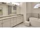 Elegant bathroom with double sinks, a soaking tub, and ample cabinet space for storage at 15923 29Th E St, Parrish, FL 34219