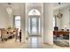 Inviting foyer featuring tile flooring, elegant lighting, and views into the dining room and an adjacent office space at 15923 29Th E St, Parrish, FL 34219
