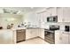 Open-concept kitchen with white cabinets, granite counters, stainless steel appliances, and modern fixtures at 15923 29Th E St, Parrish, FL 34219