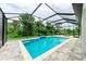 Enclosed pool and patio area with lush landscaping at 13457 Drysdale Ave, Port Charlotte, FL 33981