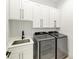 Laundry room with white cabinets, quartz countertop, and stainless steel appliances at 13457 Drysdale Ave, Port Charlotte, FL 33981
