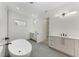 Modern bathroom with soaking tub, double vanity, and grey tile floors at 13457 Drysdale Ave, Port Charlotte, FL 33981