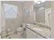 Bright bathroom featuring a granite-topped vanity, window, and neutral tile flooring at 12710 Sorrento Way # 101, Bradenton, FL 34211