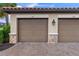 Attached two-car garage showcasing stone accents and a brick paver driveway at 12710 Sorrento Way # 101, Bradenton, FL 34211