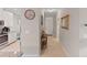 Hallway with tiled flooring, wall decor, and a view into the kitchen featuring modern, white cabinets at 12710 Sorrento Way # 101, Bradenton, FL 34211