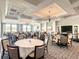 Elegant dining room with multiple tables, chairs, chandeliers and large windows for natural light at 546 Fallbrook Dr, Venice, FL 34292