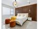 Elegant bedroom with a plush bed, statement chandelier, and wood wall at 2170 Fruitville Rd, Sarasota, FL 34237