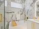 Spa-like bathroom with marble walls, a soaking tub, and gold fixtures at 2170 Fruitville Rd, Sarasota, FL 34237
