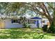 Newly renovated home with gray exterior, blue accents and landscaping at 430 Tanager Rd, Venice, FL 34293