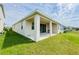 Rear exterior elevation of the home featuring a covered patio and a lush green lawn at 10827 Charlotte Dr, Parrish, FL 34219