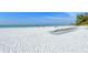 Relaxing beach scene with numerous beach chairs on the white sand with blue skies and turquoise waters at 19 Whispering Sands Dr # 204, Sarasota, FL 34242