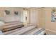 Bedroom featuring two twin beds, closet, and view of the doorway at 19 Whispering Sands Dr # 204, Sarasota, FL 34242