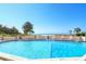 Sparkling community pool with lounge chairs overlooking the ocean at 19 Whispering Sands Dr # 204, Sarasota, FL 34242