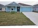 Charming single-story home showcases a blue exterior, manicured lawn, and a two-car garage at 2616 Averland Loop, North Port, FL 34287