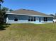 The backyard has a well-maintained lawn with a simple patio leading from a door on the house at 4865 Manila Ave, North Port, FL 34288