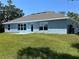 The backyard has a well-maintained lawn with a simple patio leading from a door on the house at 4865 Manila Ave, North Port, FL 34288