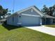 Side view of a one-story home with an attached two-car garage and a well-maintained lawn at 4865 Manila Ave, North Port, FL 34288