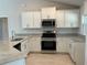Bright kitchen features granite counters, stainless appliances, white cabinets, and tile flooring at 4865 Manila Ave, North Port, FL 34288
