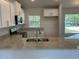 Modern kitchen with granite countertops, stainless steel appliances, and white cabinets at 4865 Manila Ave, North Port, FL 34288