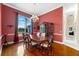 Bright dining room with hardwood floors, large window, and red walls at 17812 Doe Creek Ct, Parrish, FL 34219