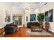 Spacious living room with hardwood floors, comfortable seating, and large artwork at 17812 Doe Creek Ct, Parrish, FL 34219