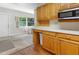 View of kitchen with wood cabinets, white appliances, and a microwave at 3740 58Th N St # 103, St Petersburg, FL 33710