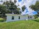 Side view of a newly painted house with a large tree in the front at 100 N Duncan Ave, Clearwater, FL 33755