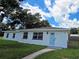 Newly renovated home with light blue door and landscaped yard at 100 N Duncan Ave, Clearwater, FL 33755