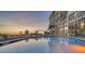 Refreshing community pool with lounge chairs at sunset at 19 Whispering Sands Dr # 204, Sarasota, FL 34242