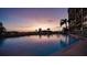 Stunning pool area with sunset view and building reflection at 19 Whispering Sands Dr # 204, Sarasota, FL 34242