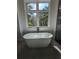 Luxurious bathroom with freestanding soaking tub and large windows at 4819 Higel Rd, Sarasota, FL 34242