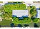 Overhead view of house nestled amongst green trees by the canal at 780 Tarawitt Dr, Longboat Key, FL 34228