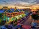 Night view of waterfront shops and restaurants with festive lights at 780 Tarawitt Dr, Longboat Key, FL 34228