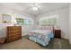Well-lit bedroom featuring a floral bedspread and dresser at 780 Tarawitt Dr, Longboat Key, FL 34228