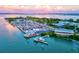 Aerial view of a marina with waterfront restaurant and boats at 780 Tarawitt Dr, Longboat Key, FL 34228