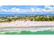 Wide sandy beach with ocean waves and many people at 780 Tarawitt Dr, Longboat Key, FL 34228