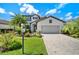 Charming two-story home with a well-manicured lawn, lush tropical landscaping, and a paver driveway at 17006 Blue Ridge Pl, Lakewood Ranch, FL 34211