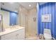 Stylish bathroom with a glass-enclosed shower, vanity, and blue and white striped wallpaper at 50 Central Ave # 17Phb, Sarasota, FL 34236
