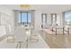 Bright dining room with modern chandelier, floor to ceiling windows, and open layout to the living area at 50 Central Ave # 17Phb, Sarasota, FL 34236