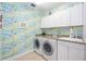 Bright laundry room featuring white cabinets, granite countertop, and side-by-side washer and dryer at 50 Central Ave # 17Phb, Sarasota, FL 34236