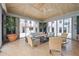 Relaxing sunroom with floor-to-ceiling windows, tiled floor, comfortable seating, and decorative plants at 50 Central Ave # 17Phb, Sarasota, FL 34236