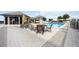 Community pool surrounded by lounge chairs, yellow umbrellas, and tables with chairs on a sunny day at 50 Central Ave # 17Phb, Sarasota, FL 34236
