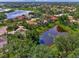 Aerial view showcasing a neighborhood with houses and a pond at 427 Autumn Chase Dr, Venice, FL 34292