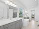 Elegant bathroom with double vanity, a large soaking tub, and a walk-in shower at 12444 Destin Loop, Venice, FL 34293