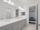 Modern bathroom with double vanity, grey cabinets, and bright lighting at 12444 Destin Loop, Venice, FL 34293