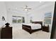 Large main bedroom with carpeted floor, a ceiling fan, and a dark wood bed frame at 12444 Destin Loop, Venice, FL 34293