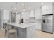 Kitchen features a large island with seating, white cabinets, and quartz countertops at 12444 Destin Loop, Venice, FL 34293